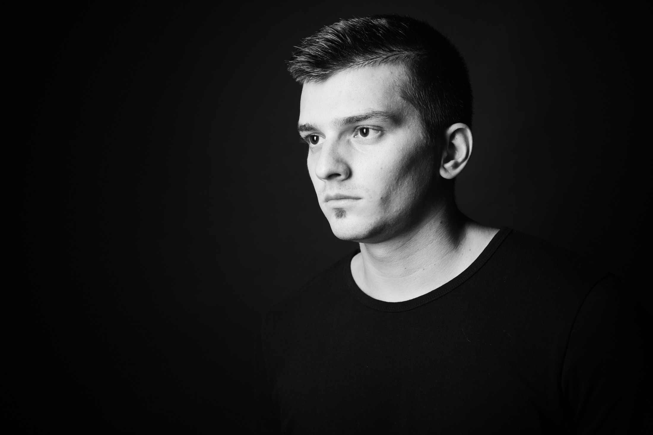 Black and white studio portrait of Jack Nova, looking off camera